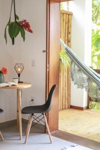 een tafel en een stoel voor een deur bij Villa Estrela Bungalow in Itacaré