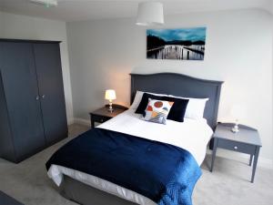 a bedroom with a bed with a blue and white comforter at Lir Lodge in Castlepollard