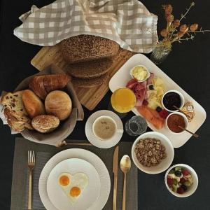 uma mesa com pequeno almoço de ovos pão e outros alimentos em B&B Hope & Anchor em Averbodeheide