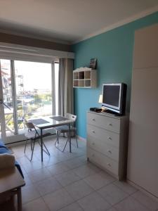 een woonkamer met een tafel en een tv op een dressoir bij Beachstudio Westende with sea view in Middelkerke