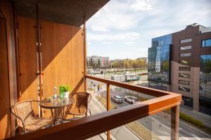 balcón con mesa, sillas y vistas a la ciudad en Apartament Greno Kielce en Kielce