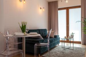 a living room with a green couch and a table at Apartament Greno Kielce - w centrum - z bezpłatnym parkingiem in Kielce
