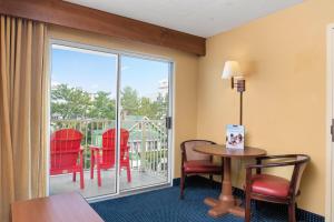 a room with a table and chairs and a balcony at Bonita Beach Hotel in Ocean City