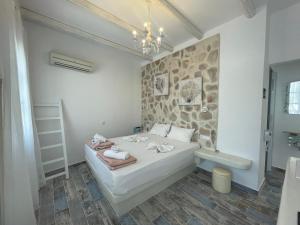 - une chambre avec un lit et un mur en pierre dans l'établissement BURGOS BARRIO, à Naxos Chora