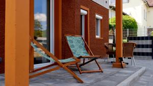 uma cadeira de baloiço sentada no alpendre de uma casa em Apartment close to Science Park em Blaustein