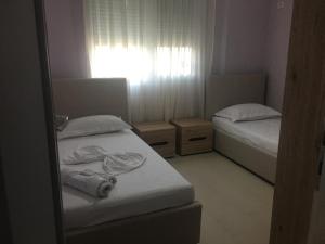 ヴロラにあるLovely apartament with the sea viewの小さなベッドルーム(ベッド2台、窓付)