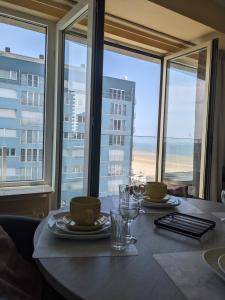 a dining table with a view of the ocean at Studio Sun south- seaview-sea at 15meter-Ostend in Ostend