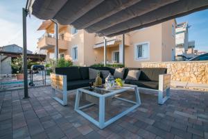 诺瓦利娅Apartment Procella的天井配有沙发和桌子。