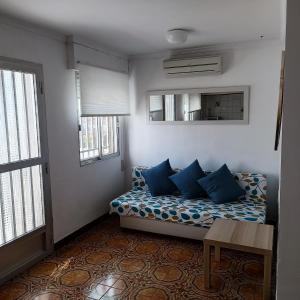 a small room with a bed with blue pillows at CASA ALTA OLIVA PLAYA in Oliva