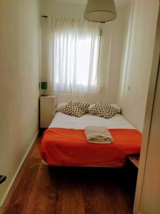 ein Schlafzimmer mit einem Bett mit einer roten Decke und einem Fenster in der Unterkunft Victoria home in Málaga