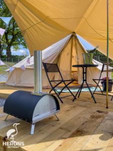Herons Retreat في Llandysul: خيمة فيها سخان وطاولة وكراسي