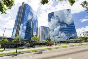 two tall glass buildings in a city with a street at Trend NCG - Apartament 1602 in Porto Alegre