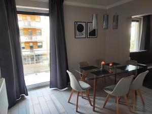 comedor con mesa, sillas y ventana en Apartament Feniks 12 - 63 m2 en Świnoujście
