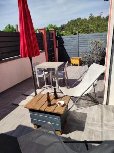 una sombrilla roja y una mesa con sillas en el techo en L'Escale d'Aubagne votre refuge chaleureux pour un séjour relaxant, en Aubagne