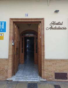 einen Eingang zu einem Gebäude mit Holztüren in der Unterkunft Hostal Andalucía in Chipiona
