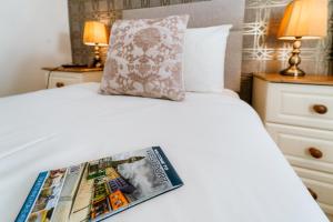 a magazine sitting on top of a bed at Plougastel House B&B in Westport +13 photos