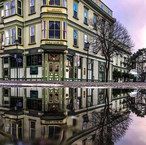 a building with its reflection in a puddle of water at The Inn at 2nd & C in Eureka