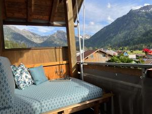 a bed on a balcony with a view of mountains at Ferienwohnung Bergglück in Hinterstein