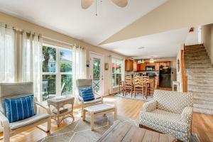 an open living room with chairs and a kitchen at Compass Rose II in Folly Beach