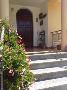 a front door of a house with pink flowers at Anna Rita Alghero B&B in Fertilia