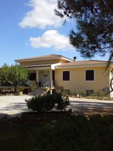 a house with a car parked in front of it at Anna Rita Alghero B&B in Fertilia