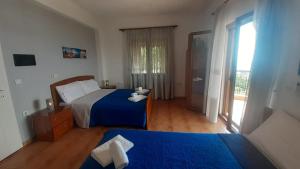 a bedroom with two beds and a door to a balcony at Rooms to let Spiropali in Piqeras +34 photos