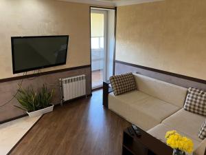 a living room with a couch and a flat screen tv at VIP апартаменти ЦЕНТР in Rivne