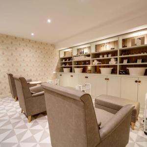 a waiting room with chairs and a table and shelves at St Moritz Hotel and Cowshed Spa in Polzeath