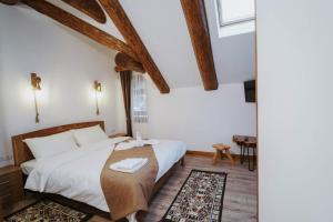 a bedroom with a bed in a room with wooden ceilings at Hanul lui Mujdei in Vatra Dornei