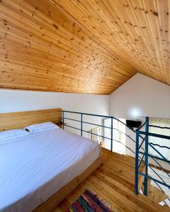 a bedroom with a bed and a wooden ceiling at Tonea's Houses in Himare