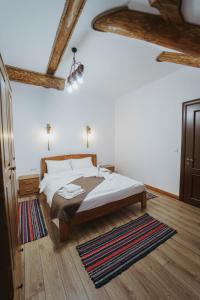 a bedroom with a bed in a room with wooden ceilings at Hanul lui Mujdei in Vatra Dornei