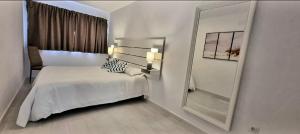 um quarto branco com uma cama e um espelho em Cardón Jandía 1B em Morro del Jable
