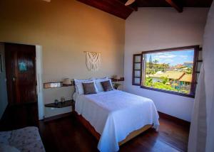 a bedroom with a bed and a large window at Oceanica 1000 Beachfront Suites in Saquarema +61 photos