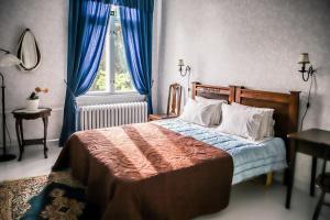 a bedroom with a bed with blue curtains and a window at Neitsytniemen Kartanohotelli in Imatra