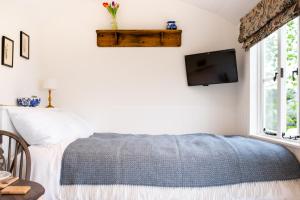a bedroom with a bed and a tv on the wall at Drift View Shepherds Hut in Melton Mowbray