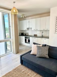 2 Bedroom Serviced Apartment with Free Parking, Wifi & Netflix, Basingstoke في باسينغستوك: غرفة معيشة مع أريكة ومطبخ