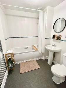 y baño con bañera, aseo y lavamanos. en 2 Bedroom Serviced Apartment with Free Parking, Wifi & Netflix, Basingstoke en Basingstoke