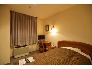 千葉市にあるFamy Inn Makuhari - Vacation STAY 16035vのベッドと机とパソコンが置かれたホテルの部屋