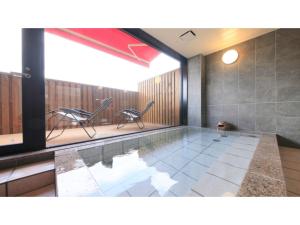a swimming pool with two chairs in a room at HOTEL COONEL INN - Vacation STAY 33521v in Susono