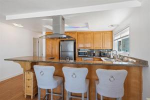 a kitchen with a large island with bar stools at 104-unit 4 in San Diego