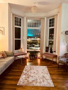 uma sala de estar com um sofá e uma grande janela em Southsea Retreat em Southsea