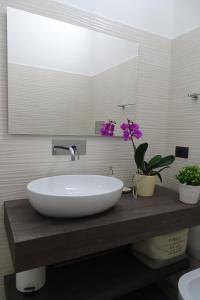 lavabo blanco en un baño con flores en una encimera en Sailor's House Porto Cervo, en Porto Cervo