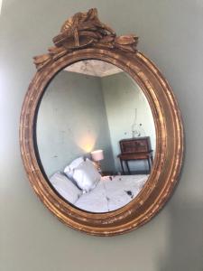 a mirror on a wall with a bed in a room at Rouge Maison in Bois-Normand-près-Lyre