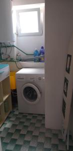 pralka w łazience z oknem w obiekcie Apartman Zvončica w mieście Vrsi