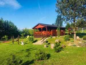 Cabaña de madera en un campo con parque infantil en Domki letniskowe przy lesie - "U Łastka", en Bartołty Wielkie