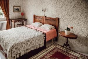 a bedroom with a bed and a table at Neitsytniemen Kartanohotelli in Imatra