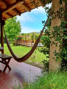 a hammock on a porch with a view of a yard at Complejo Retana in Potrero de los Funes