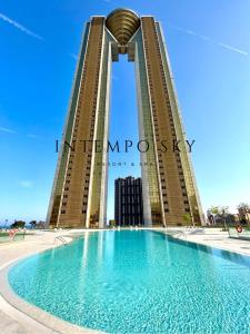 un hotel con piscina frente a un edificio en INTEMPO SKY Resort & Spa, en Benidorm