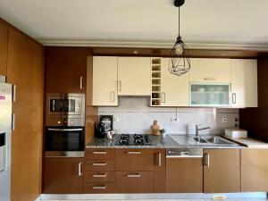 a kitchen with wooden cabinets and a stove top oven at My Place in Portimão