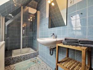 a blue tiled bathroom with a sink and a shower at Südhörn in Horumersiel